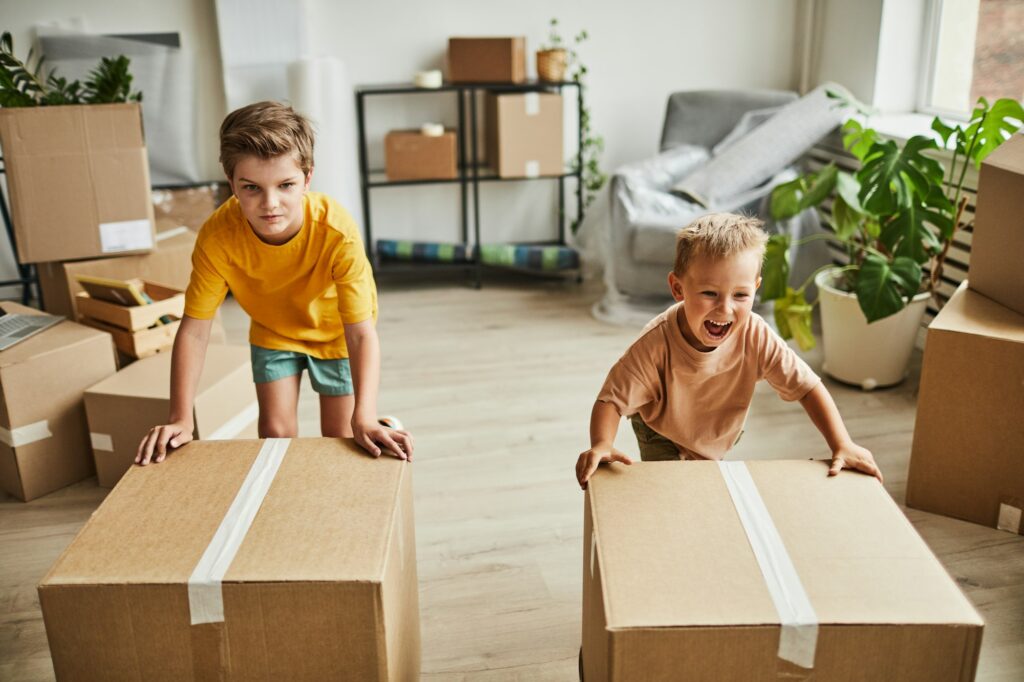 Boys Moving Boxes in New House