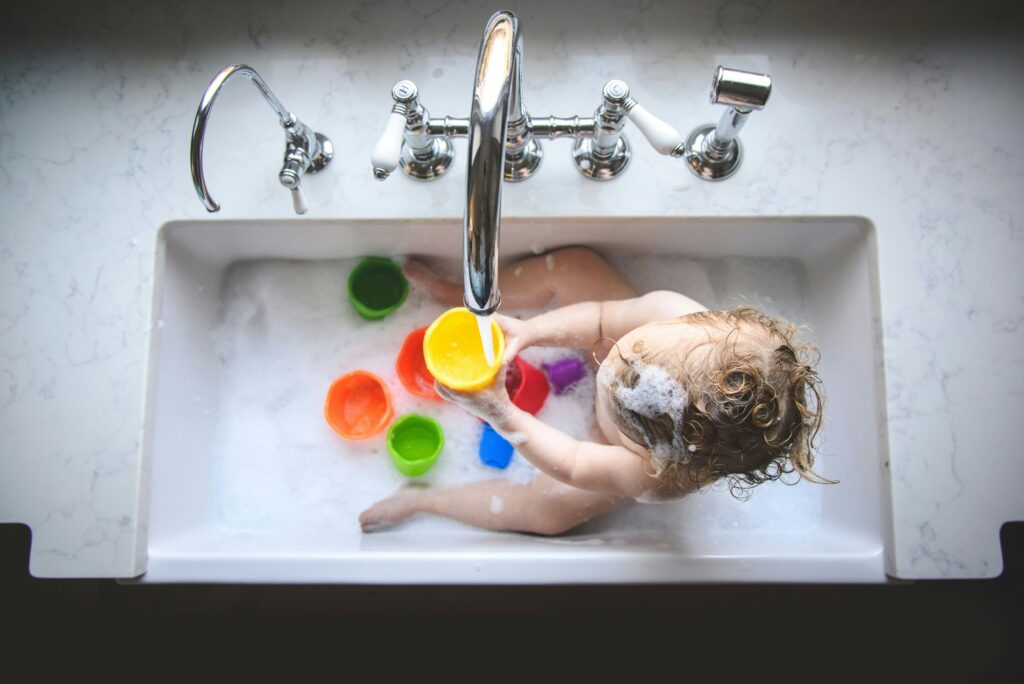 baby girl at home in kitchen sink