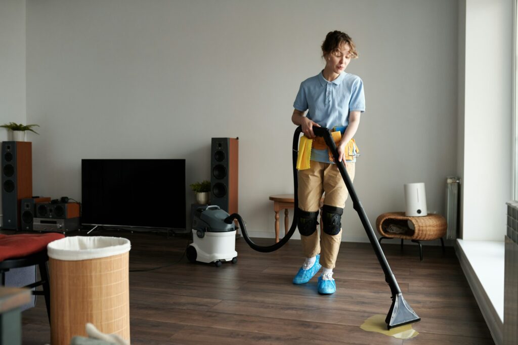 Professional cleaner vacuuming the apartment