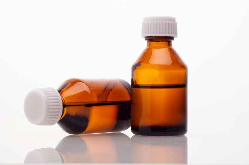 two brown glass vial on a white background