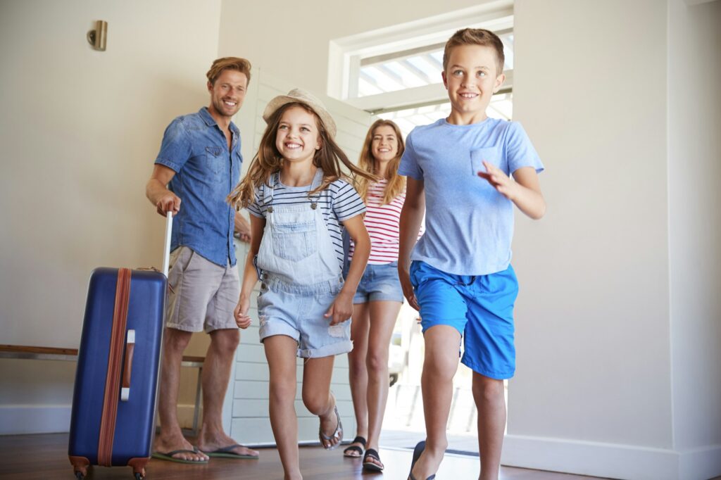 Family Arriving At Summer Vacation Rental