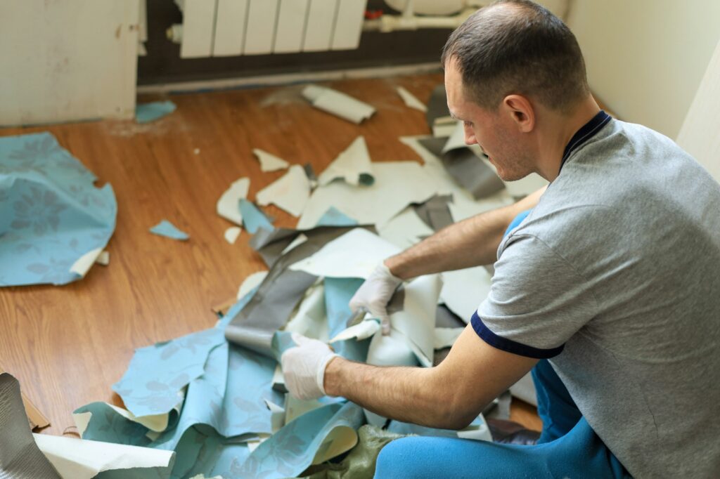 Middle-aged man cleans construction debris after renovation in his apartment